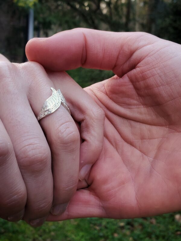 bague de fiançailles sur doigt de femme tenue par main d'homme