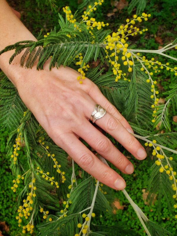 Bague de Fiançailles portée sur fond de mimosa