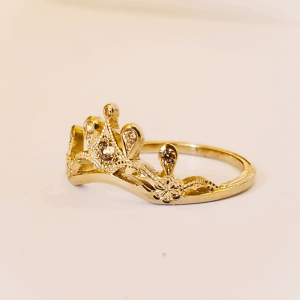 Bague diadème en or jaune et diamants sur fond clair.