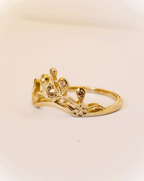 Bague diadème en or jaune et diamants sur fond clair.